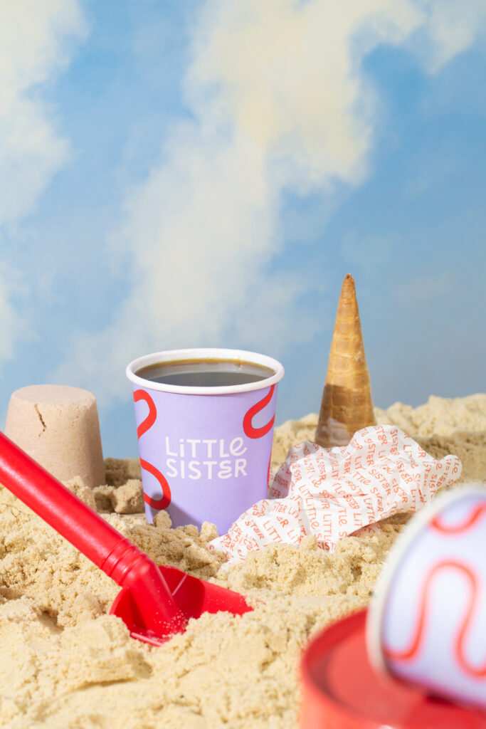 little sister, ice cream and coffee shop designed by Angel & Anchor and the Lost & Found team, Portsteward, Ireland, UK. Styled image of coffee and ice cream in the sand at the beach